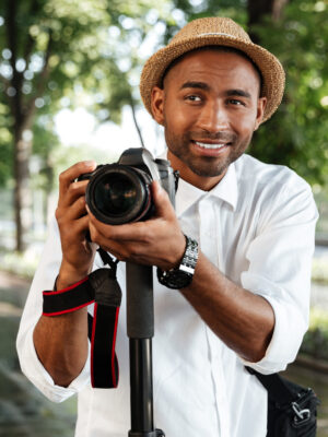 Funny black man in park with camera and hat